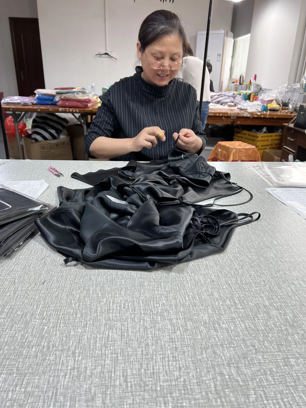 Factory craftsperson completing hand finishing on a garment