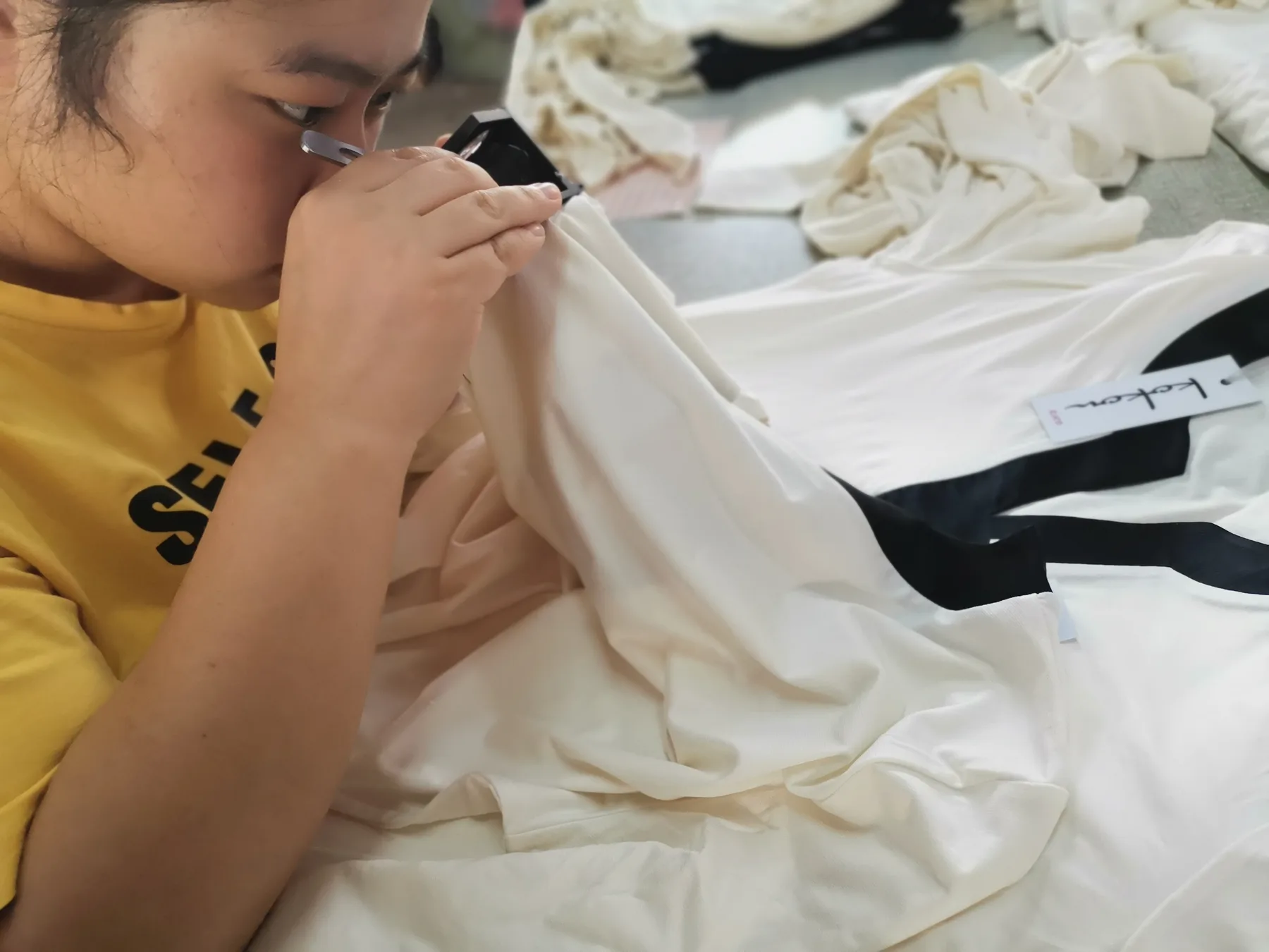 Inspector reviewing the surface of a silk product with a magnifier