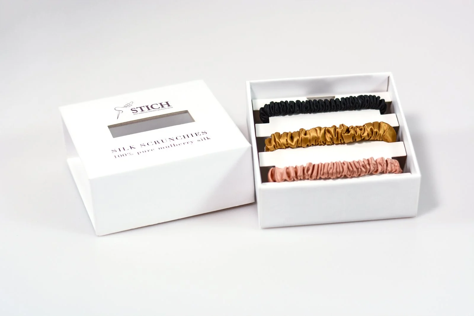 Custom white gift box presenting three skinny silk scrunchies