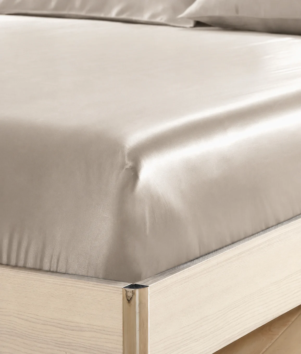 Champagne silk fitted sheet wrapping smoothly around a mattress corner