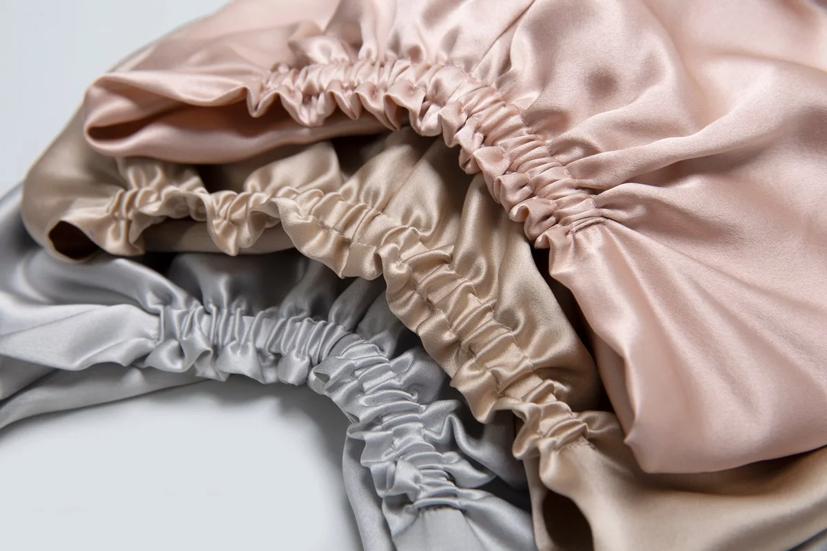 Blush, champagne, and silver silk bonnets arranged to compare gathered-edge consistency