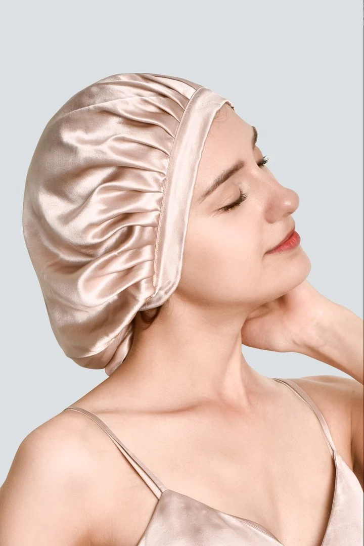 Woman wearing a blush silk bonnet with a smooth wide band