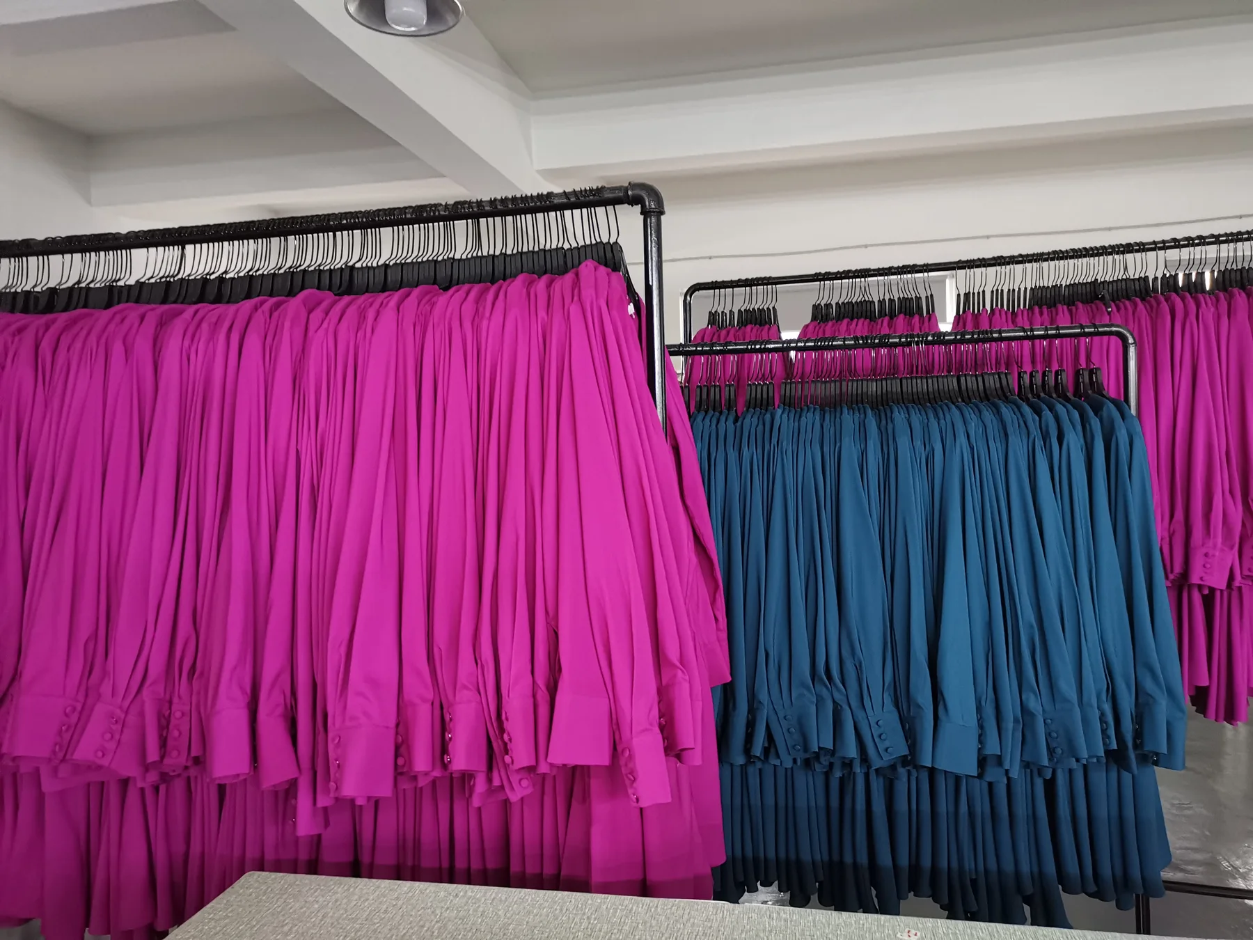 Finished colorful garments arranged on production racks