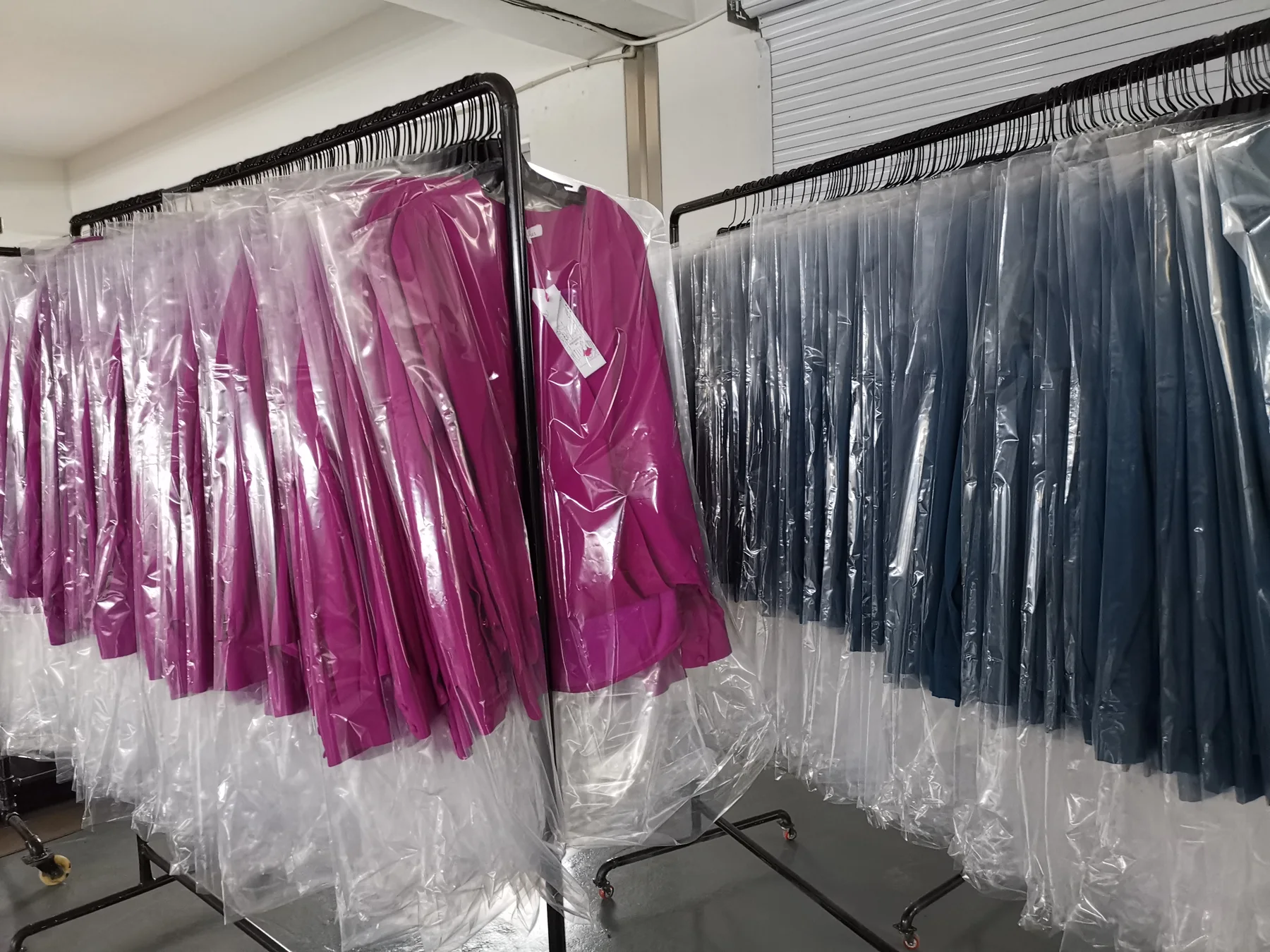Finished garments individually bagged on hangers and organized on racks for shipment