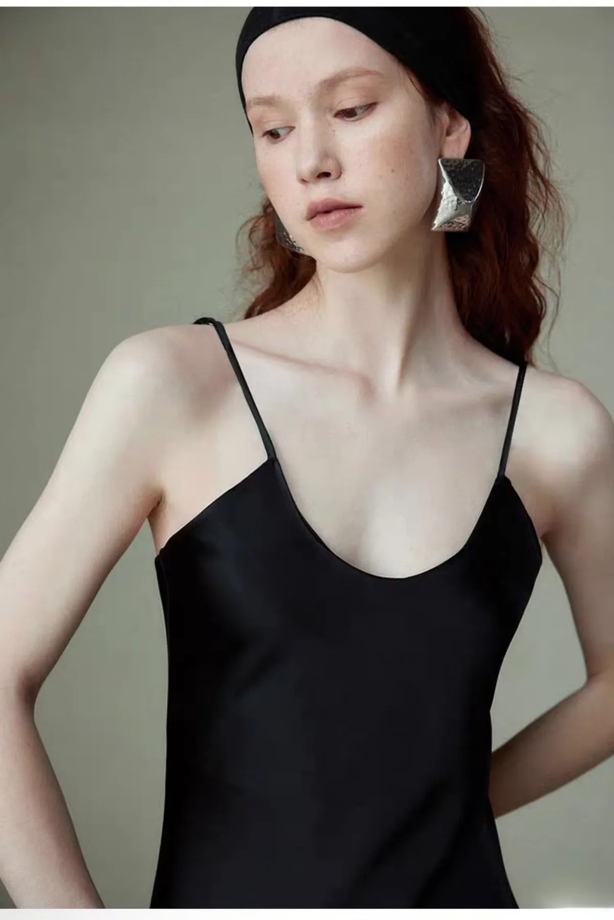 Nahaufnahme von Ausschnitt und schmalen Trägern eines schwarzen Seiden-Slipdresses