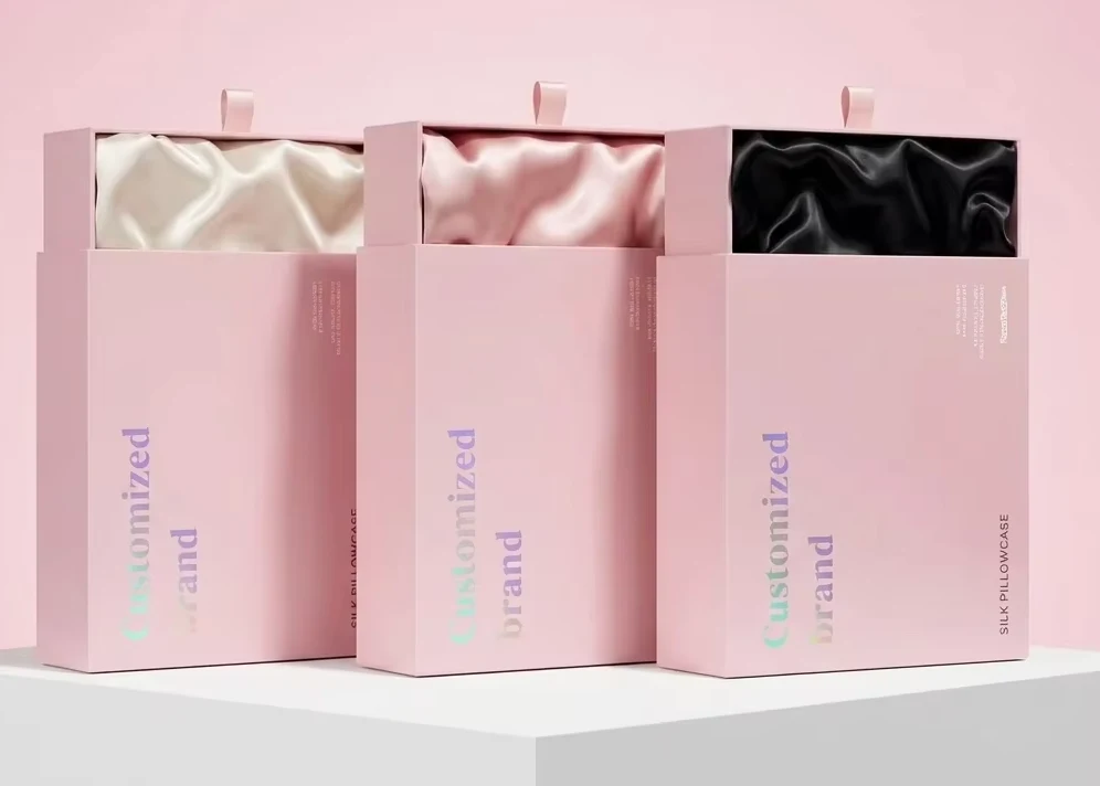 Pink drawer gift boxes displaying ivory, pink, and black silk pillowcases